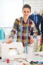 Happy seamstress in studio near sewingmachine Royalty Free Stock Photo