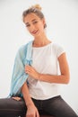 Happy seated casual woman with shirt on shoulder