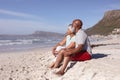 Happy senior african american couple sitting together on the beach Royalty Free Stock Photo