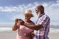 Happy senior african american couple using smartphone at the beach Royalty Free Stock Photo