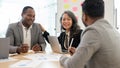 A happy senior Asian businesswoman is in a meeting with African American businessmen Royalty Free Stock Photo