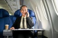 A happy senior Asian businesswoman is on the phone during the flight, going on her business trip Royalty Free Stock Photo