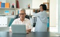 Happy senior Asian couple using a laptop at home for find new tourist attractions together. Happy retirement with planning, saving