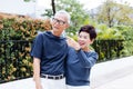 Happy senior Asian couple walking and pointing in outdoor park and house. Royalty Free Stock Photo