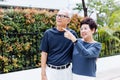 Happy senior Asian couple walking and pointing in outdoor park and house.