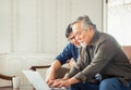 Happy senior asian father and adult son using Computer laptop talking on video call in living room Royalty Free Stock Photo