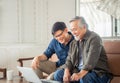 Happy senior asian father and adult son using laptop talking on video call in living room Royalty Free Stock Photo