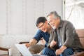 Happy senior asian father and adult son using laptop talking on video call in living room Royalty Free Stock Photo