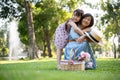 Happy senior Asian grandmother and her cute little girl granddaughter are hugging in the green park Royalty Free Stock Photo