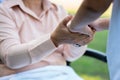 Happy senior Asian grandmother uses wheelchair with her daughter and grandchild in park, Grandson came to visit elderly