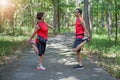 Happy senior asian woman with man or personal trainer stretch thigh muscles at park