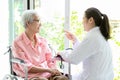 Happy senior asian woman and doctor or nurse talking,enjoying together,female caregiver or friendship supporting smiling elderly Royalty Free Stock Photo