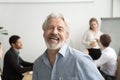 Happy senior businessman laughing looking at camera in office, p Royalty Free Stock Photo