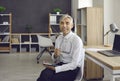 Happy senior businessman sitting on chair in his office, holding glasses and smiling Royalty Free Stock Photo