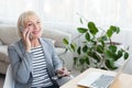 Elderly businesswoman talking on phone, consulting client Royalty Free Stock Photo