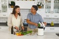 Happy senior caucasian couple in modern kitchen, cooking together composting organic waste