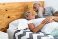 Happy senior couple in bed - Hipster mature people having funny bed time together