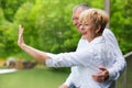 Happy senior couple on bridge waving hands Royalty Free Stock Photo