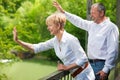 Happy senior couple on bridge waving hands Royalty Free Stock Photo