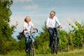 Happy senior couple cycling outdoors in summer Royalty Free Stock Photo