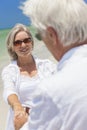 Happy Senior Couple Dancing Holding Hands on Beach Royalty Free Stock Photo