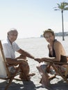 Happy Senior Couple On Deckchairs At Beach Royalty Free Stock Photo