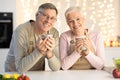 Happy Senior Couple Drinking Coffee Celebrating Christmas Sitting In Kitchen Royalty Free Stock Photo