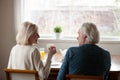 Happy senior couple drinking tea chatting at home, rear view Royalty Free Stock Photo