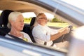 Happy senior couple driving in car