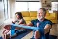 A senior couple indoors at home, doing exercise on the floor. Royalty Free Stock Photo