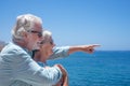 Happy senior couple embraced standing at the sea enjoying summer and sun Royalty Free Stock Photo