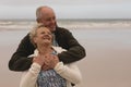 Happy senior couple embracing standing at the the beach Royalty Free Stock Photo