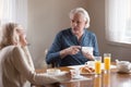 Happy aged husband and wife enjoy breakfast at home Royalty Free Stock Photo