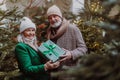 Happy senior couple enjoying christmas market, buying gifts and christmas tree. Royalty Free Stock Photo