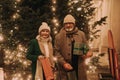 Happy senior couple enjoying christmas market, buying gifts and christmas tree. Royalty Free Stock Photo