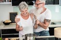 Happy senior couple enjoying and cooking healthy dinner together at home - Focus on faces Royalty Free Stock Photo