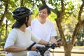 Happy senior couple enjoying riding bicycles in summer park. Retirement and healthy lifestyle. Royalty Free Stock Photo