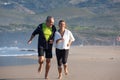 Happy senior couple enjoying running barefoot on sand near sea Royalty Free Stock Photo