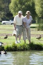 Happy Senior Couple Feeding Ducks Royalty Free Stock Photo