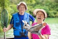 Happy Senior couple fishing at the lakeside