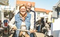 Happy senior couple having fun on bicycle at city market - Active playful elderly concept riding bike at retirement time Royalty Free Stock Photo