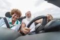 Happy senior couple having fun in convertible car during summer vacation - Focus on hipster man face Royalty Free Stock Photo