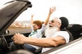 Happy senior couple having fun in convertible car during summer vacation - Focus on man face Royalty Free Stock Photo