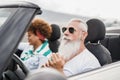 Happy senior couple having fun in convertible car during summer vacation - Focus on senior man face Royalty Free Stock Photo