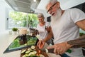 Happy senior couple having fun cooking together at home - Elderly people preparing health lunch in modern kitchen Royalty Free Stock Photo