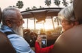 Happy senior couple having fun driving on new convertible car - Mature people enjoying time together during road trip tour Royalty Free Stock Photo