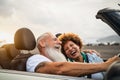 Happy senior couple having fun driving on new convertible car - Mature people enjoying time together during road trip Royalty Free Stock Photo