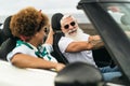 Happy senior couple having fun driving on new convertible car - Mature people enjoying time together during road trip Royalty Free Stock Photo