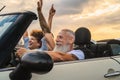 Happy senior couple having fun driving on new convertible car - Mature people enjoying time together during road trip Royalty Free Stock Photo