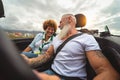 Happy senior couple having fun driving on new convertible car - Mature people enjoying time together during road trip Royalty Free Stock Photo